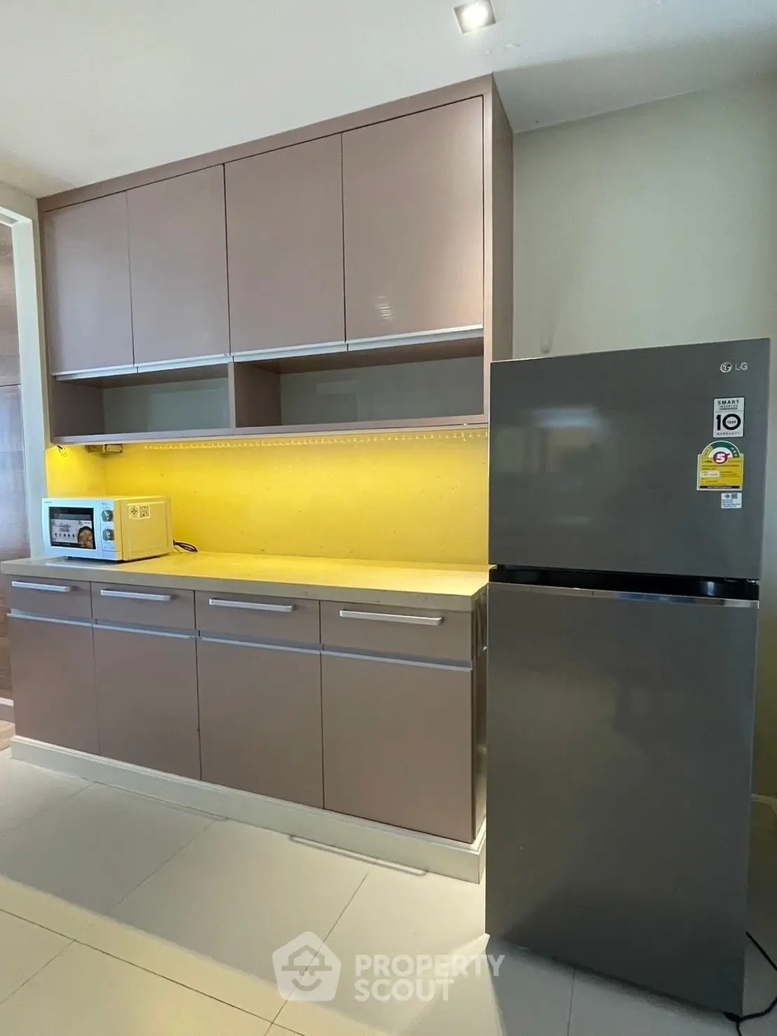 Modern kitchen with sleek cabinets and stainless steel fridge in a stylish apartment.