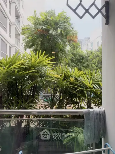 Lush green balcony view with tropical plants in modern apartment complex