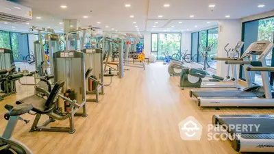 Spacious modern gym with state-of-the-art equipment and natural lighting.