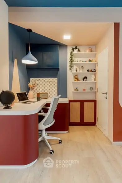 Stylish home office with modern desk, chair, and decorative shelves in vibrant colors.
