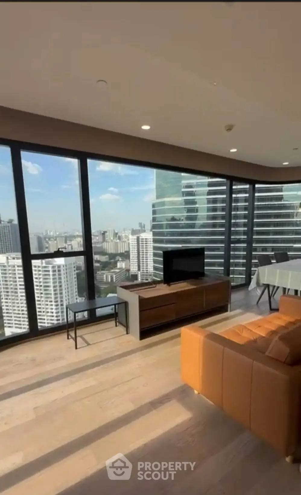 Luxurious corner unit living room with panoramic city views and modern furnishings.