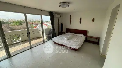 Spacious bedroom with balcony and city view in modern apartment