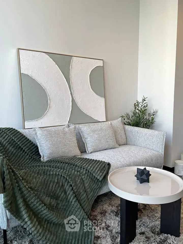 Modern living room with stylish sofa, abstract art, and cozy decor