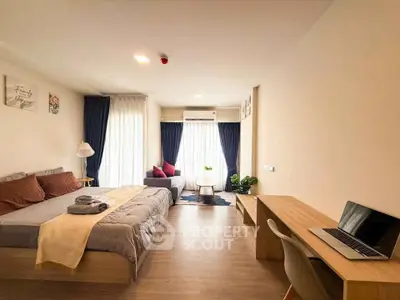 Spacious studio apartment with modern decor, featuring a cozy bed, stylish sofa, and a sleek workspace.