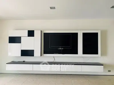 Modern living room with sleek wall-mounted TV and stylish storage units.