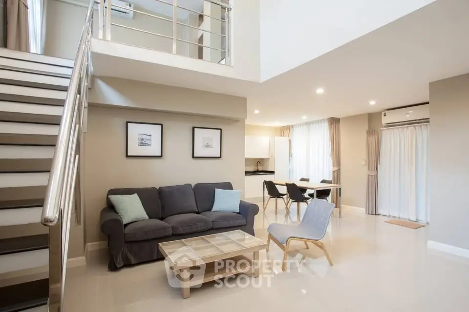 Spacious modern living room with open layout and stylish furniture in a duplex apartment.