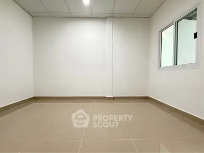 Spacious empty room with tiled flooring and white walls, ideal for customization.