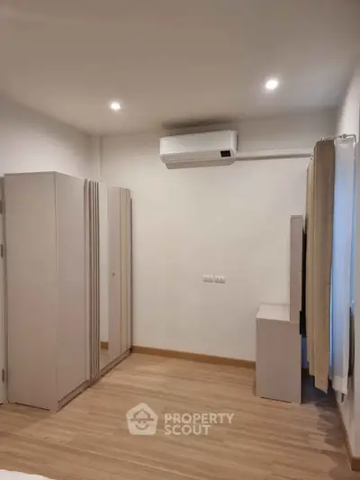 Spacious bedroom with modern air conditioning and sleek wardrobe design.