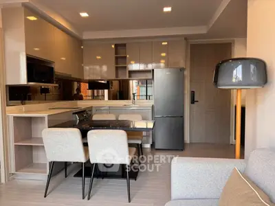 Modern kitchen with sleek cabinetry, stainless steel appliances, and cozy dining area in open layout.