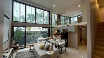 Luxurious modern living room with high ceilings and large windows in a stylish apartment.