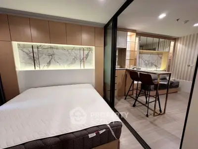 Modern bedroom with stylish decor and open layout kitchen in a contemporary apartment.