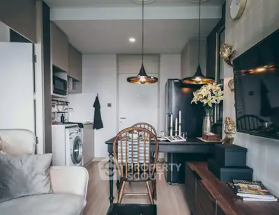 Chic modern living room with open kitchen, stylish lighting, and cozy seating area.