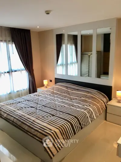 Cozy bedroom with modern decor and ample natural light, featuring a comfortable bed and stylish bedside lamps.
