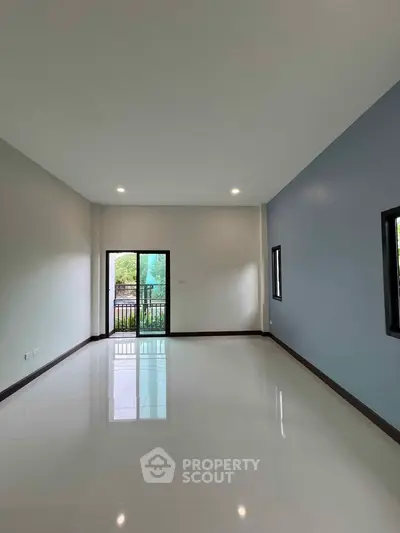 Spacious empty living room with large windows and balcony view