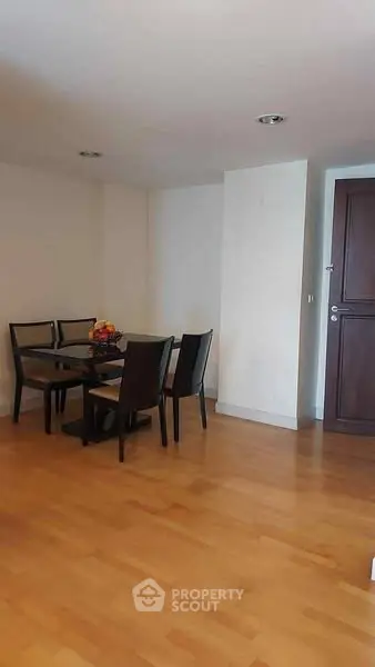 Cozy dining area with wooden flooring and elegant dark wood furniture.