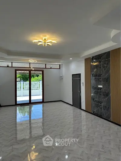 Spacious modern living room with elegant lighting and large windows offering natural light.