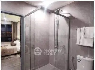 Modern bathroom with glass shower and view into bedroom