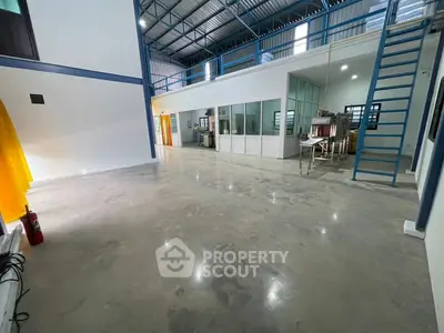 Spacious industrial-style interior with high ceilings and mezzanine level