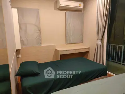 Cozy bedroom with modern air conditioning and balcony access, perfect for urban living.