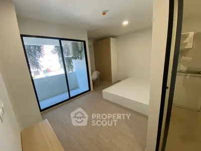 Modern minimalist bedroom with balcony and wooden flooring