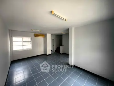 Spacious empty room with tiled floor and bright lighting, ideal for customization.