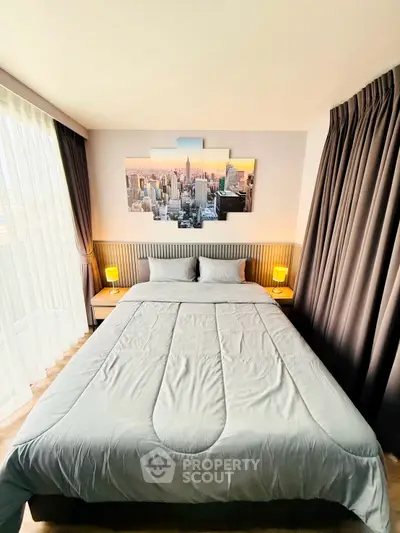 Modern bedroom with large bed and cityscape artwork, featuring elegant curtains and ambient lighting.