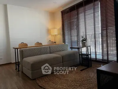 Cozy living room with modern sofa, wooden blinds, and warm lighting