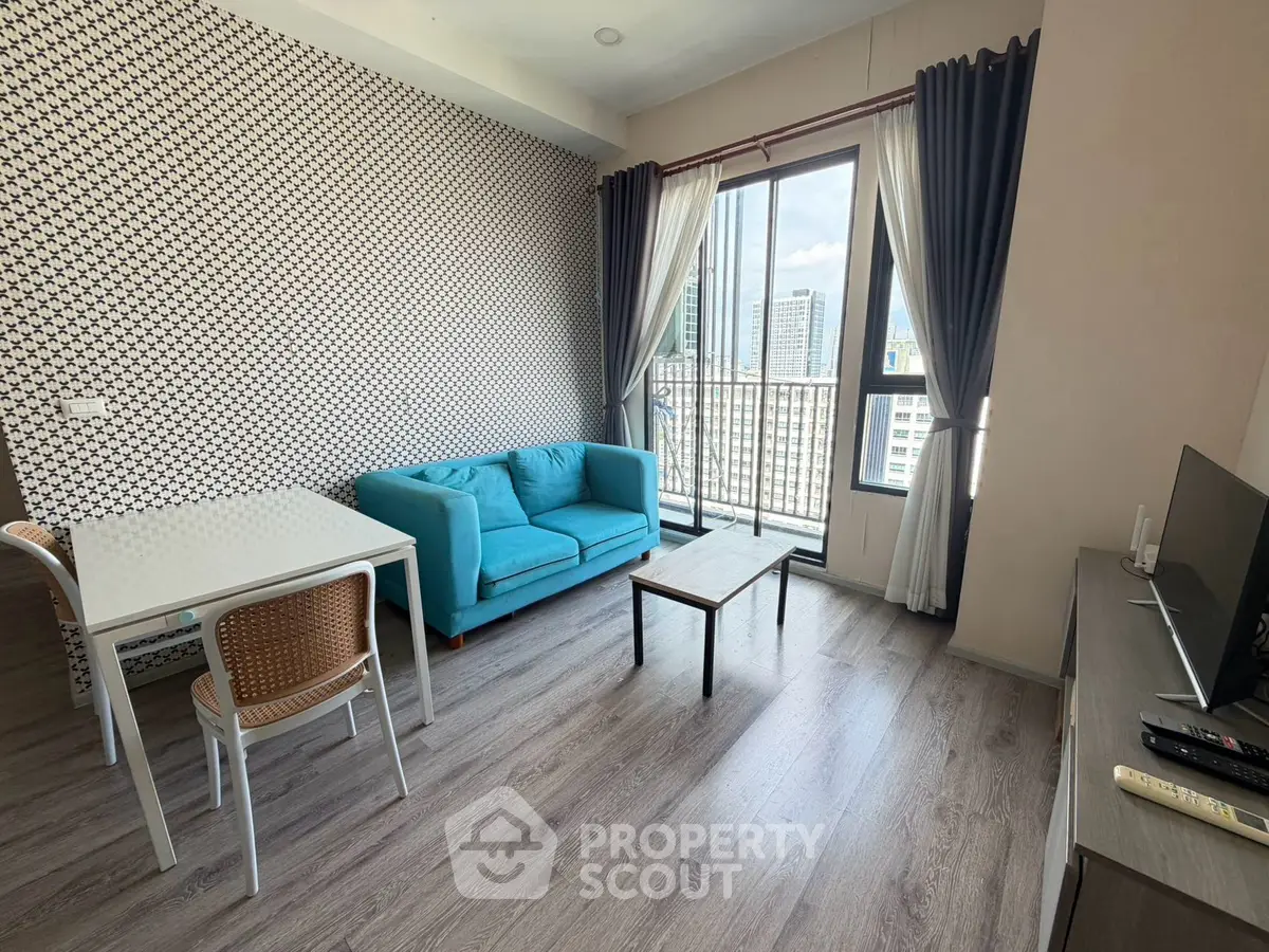 Modern living room with city view, stylish decor, and natural light in urban apartment.