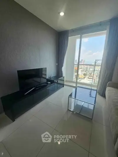 Modern living room with sleek TV stand and stunning city view through large windows.