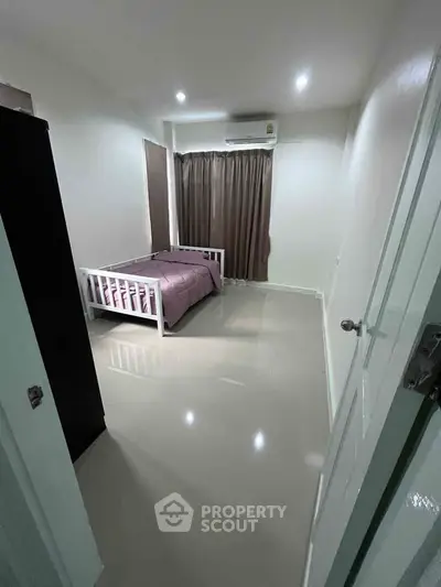 Modern minimalist bedroom with sleek flooring and cozy bed setup