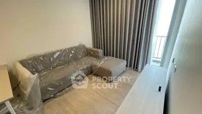 Modern living room with sleek sofa and floor-to-ceiling curtains, offering a cozy ambiance.