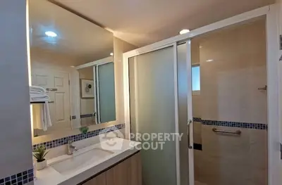 Modern bathroom with sleek shower and elegant vanity in contemporary home.