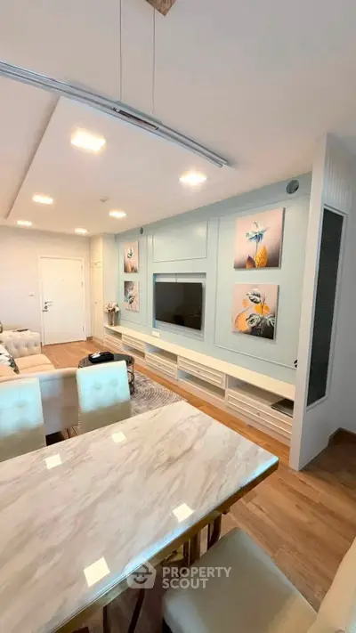 Modern living room with elegant decor and stylish furniture, featuring a sleek entertainment unit and cozy dining area.