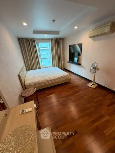 Cozy bedroom with wooden flooring, air conditioning, and modern decor.