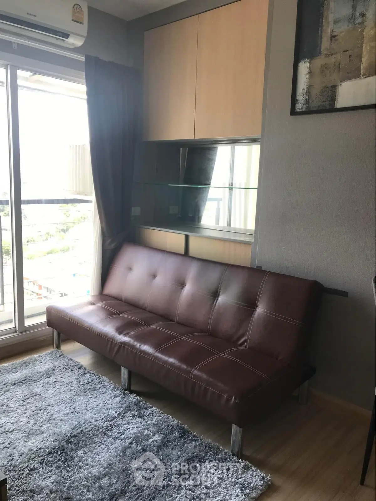 Modern living room with leather sofa and large window view