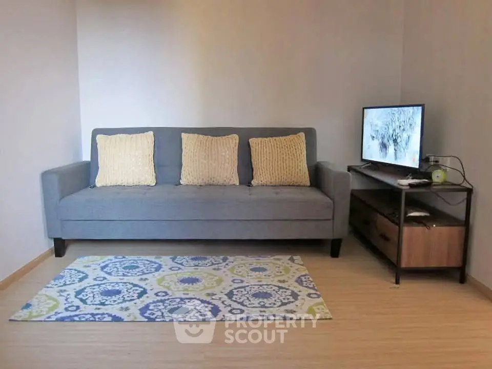 Cozy living room with modern sofa and TV setup, perfect for relaxation.