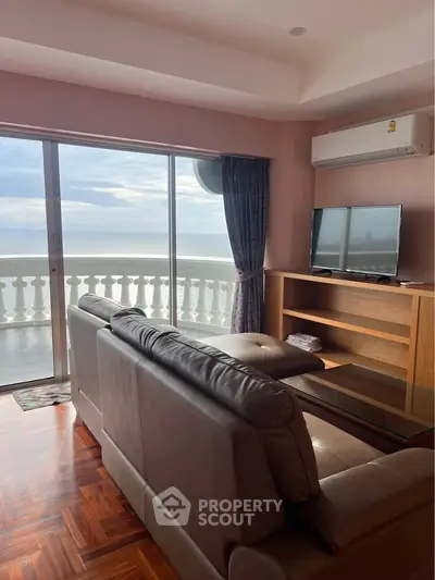 Luxurious living room with ocean view and elegant balcony, featuring modern furniture and large windows.