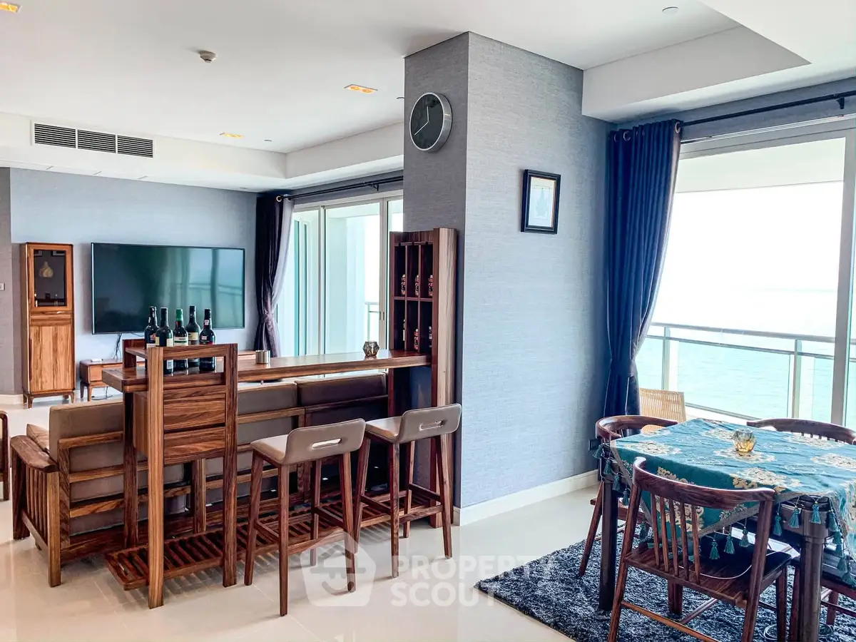 Luxurious living room with ocean view, elegant wooden furniture, and spacious balcony access.