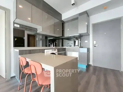 Modern kitchen with sleek cabinetry and dining area in contemporary apartment