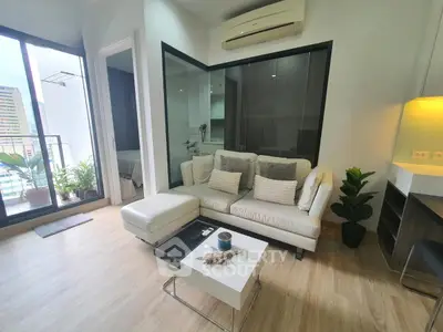 Modern living room with sleek design, large windows, and balcony access in a stylish apartment.