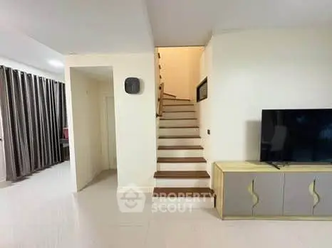Modern living room with staircase and stylish TV console