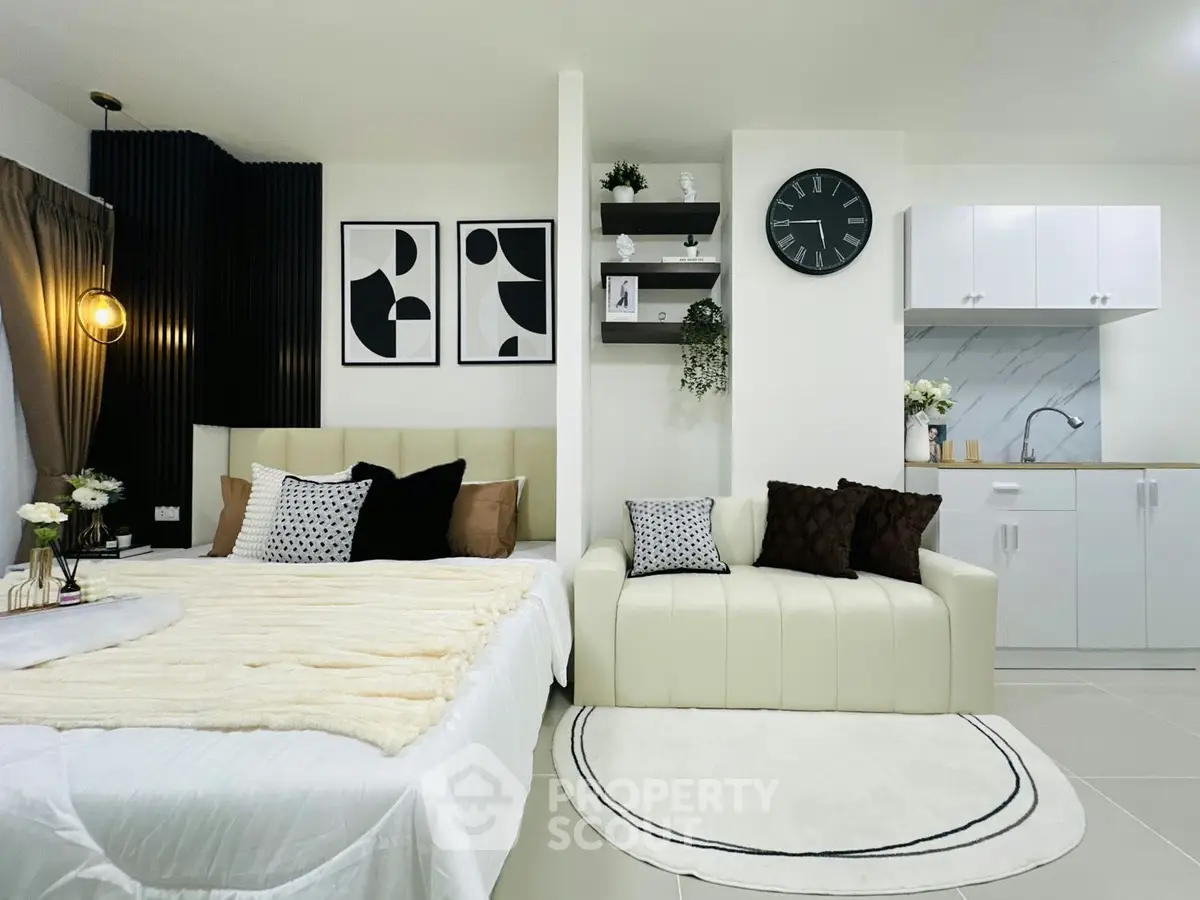 Modern studio apartment with stylish decor and compact kitchen area