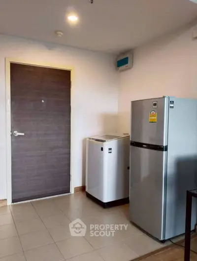 Modern kitchen with fridge and washing machine in compact space