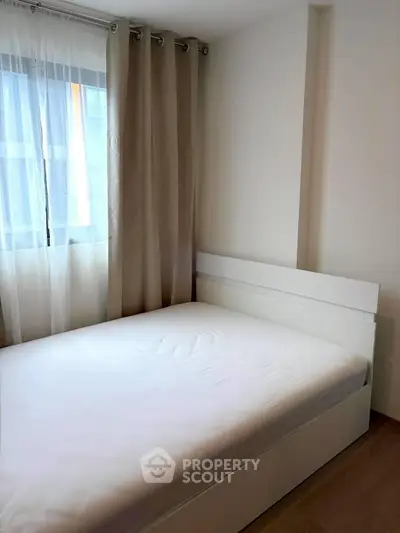 Cozy bedroom with natural light and modern furnishings in a stylish apartment.