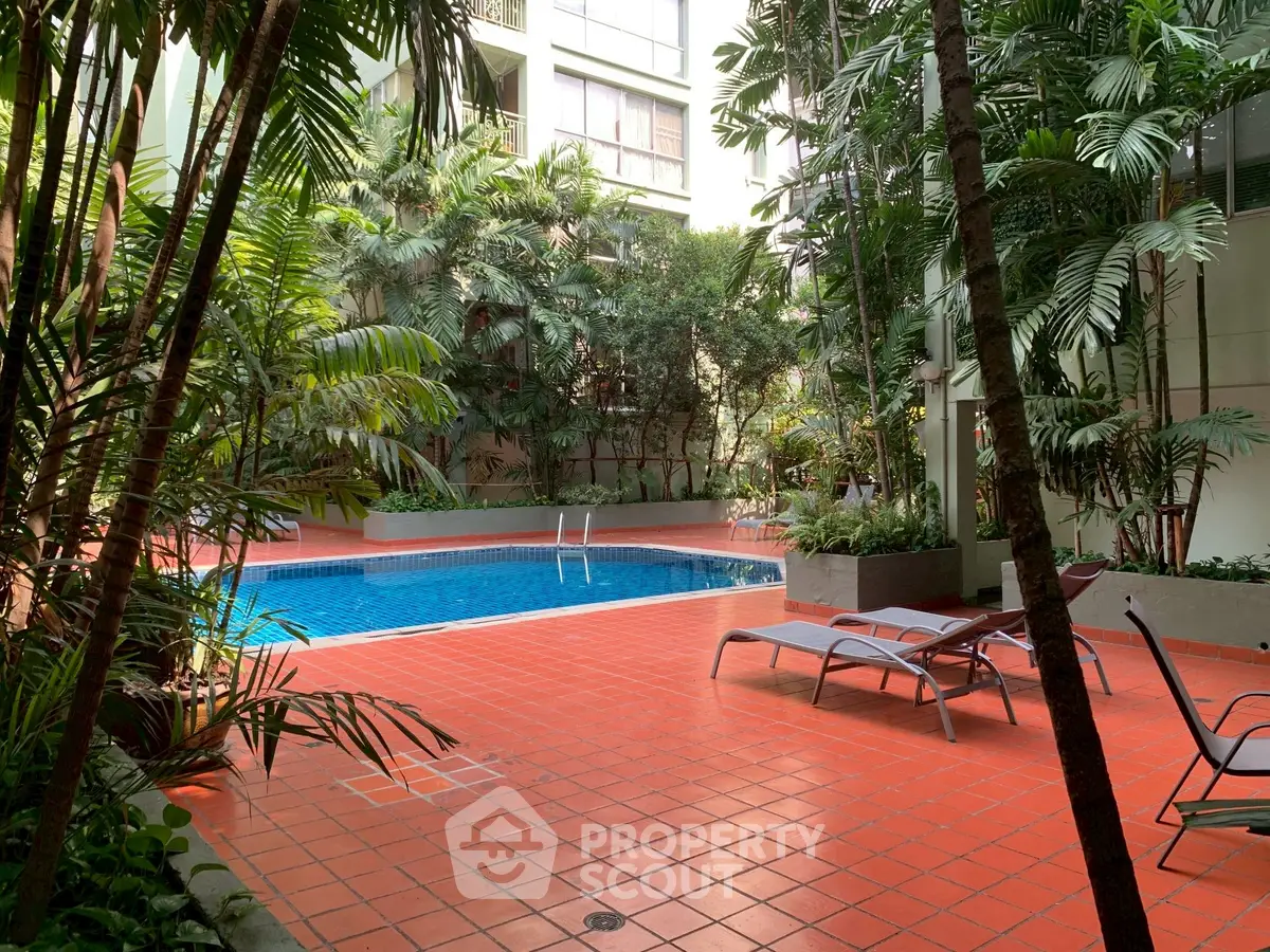 Luxurious apartment complex with serene pool and lush greenery for ultimate relaxation.
