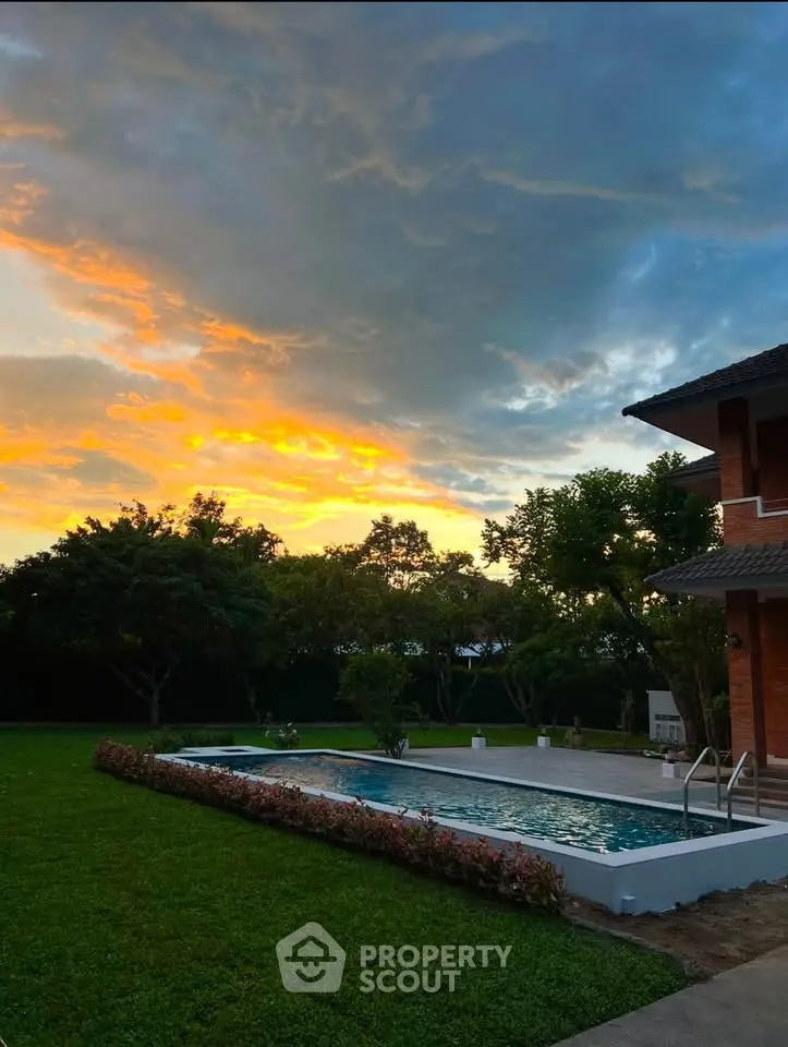 Stunning sunset view over modern home with pool and lush garden