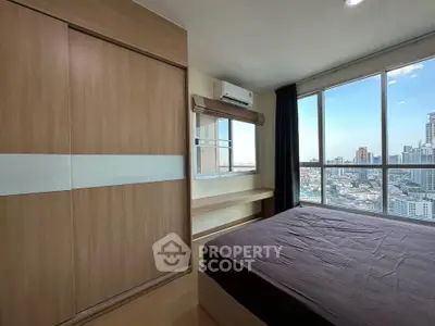 Spacious bedroom with city view and modern wooden wardrobe in high-rise apartment.