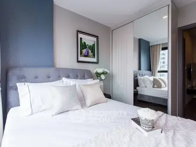 Modern bedroom with stylish decor and mirrored wardrobe in a cozy apartment.