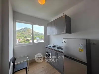 Modern kitchen with scenic view, featuring sleek cabinetry and stainless steel appliances.