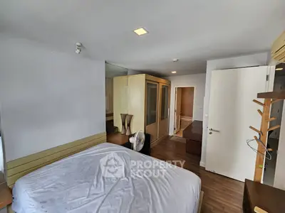 Spacious bedroom with modern furnishings and wooden flooring